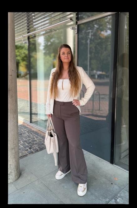Lena Peter, UGC Creatorin, steht vor einer Glasfront